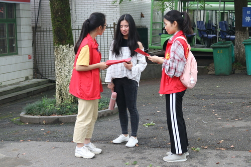 志愿者给学生发放伤寒知识传单